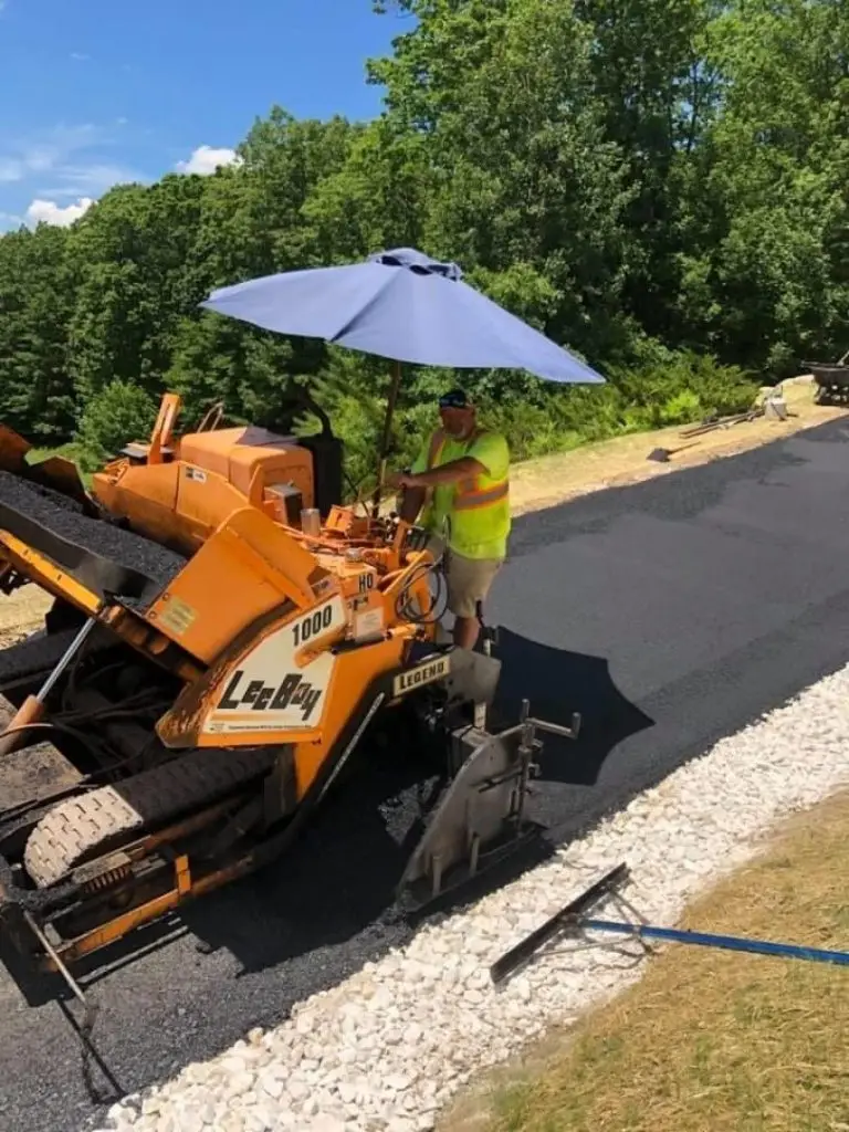 Crew operating the LeeBoy paver on a driveway with stone edging