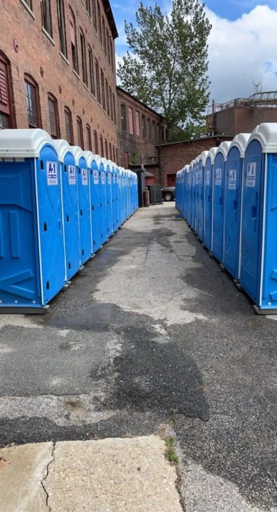 Rows of A1 portable toilets set up between brick mill buildings